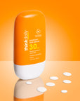 Orange sunscreen bottle labeled 'thinkdaily' on an orange background