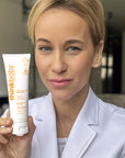 Person holding ThinkBaby Clear Zinc 30 SPF Sunscreen, highlighting its broad-spectrum UV protection and hypoallergenic, reef-friendly formula.