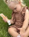 Thinkbaby sunscreen applied outdoors on grass, showing gentle mineral sunscreen suitable for little ones with easy application and skin‑friendly formula.